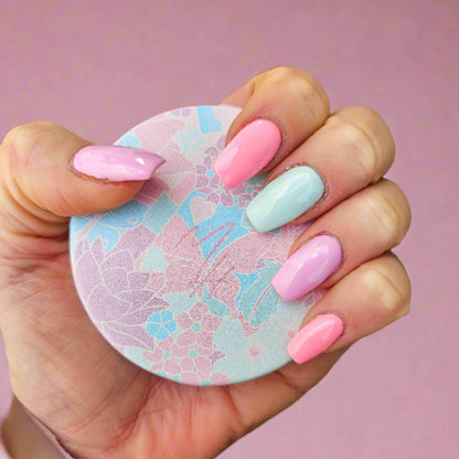A hand holding a round pastel pocket mirror with a floral pattern. Pastel butterfly pocket mirror by Mel Style — MH monogram design