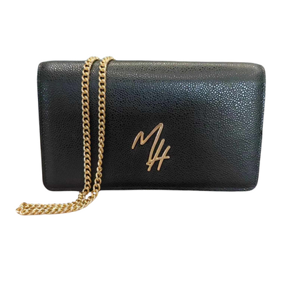 A black leather handbag with a gold-toned chain shoulder strap, silver hardware, and a gold signature logo on the front.